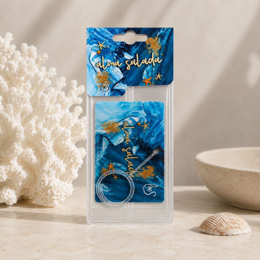 Ambientador de coche Alma Salada de LoeS en su packaging junto a coral blanco, cuenco de cerámica y arena de playa – D'Arome