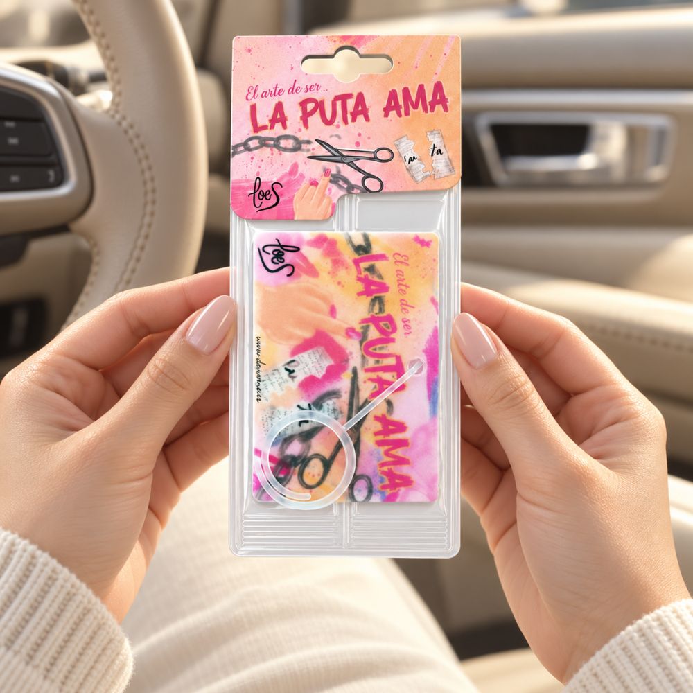 Sujetando con ambas manos el ambientador de coche La Puta Ama LoeS dentro del vehículo – D'Arome