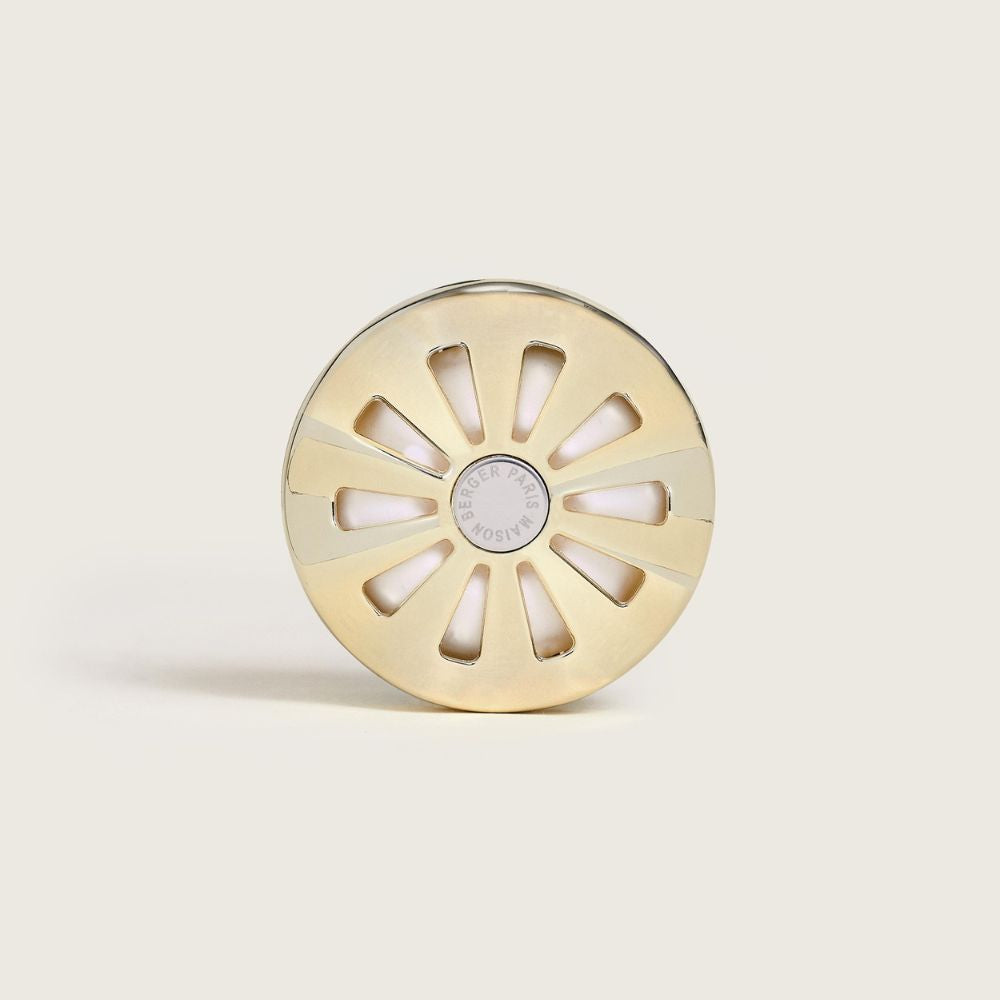 Vista frontal del ambientador de coche Poussière d'Ambre Maison Berger con su diseño dorado en forma de sol – D'Arome