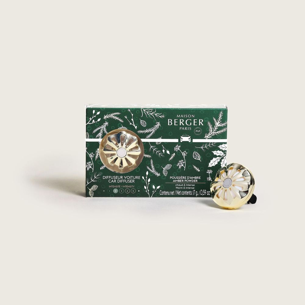 Ambientador de coche Poussière d'Ambre Maison Berger junto a su caja de edición Navidad con motivos vegetales verdes – D'Arome