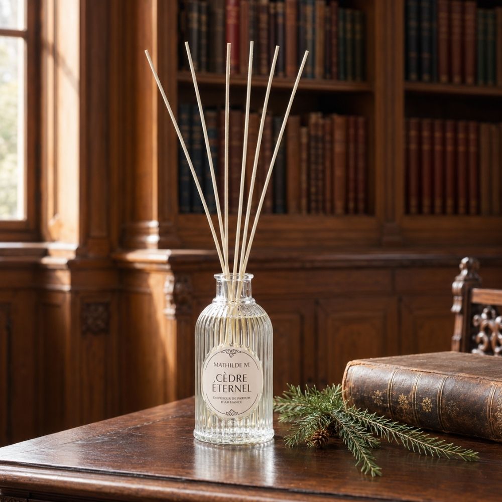 Ambientador mikado Cèdre Éternel de Mathilde M sobre mesa de madera con librería clásica de fondo – D'Arome