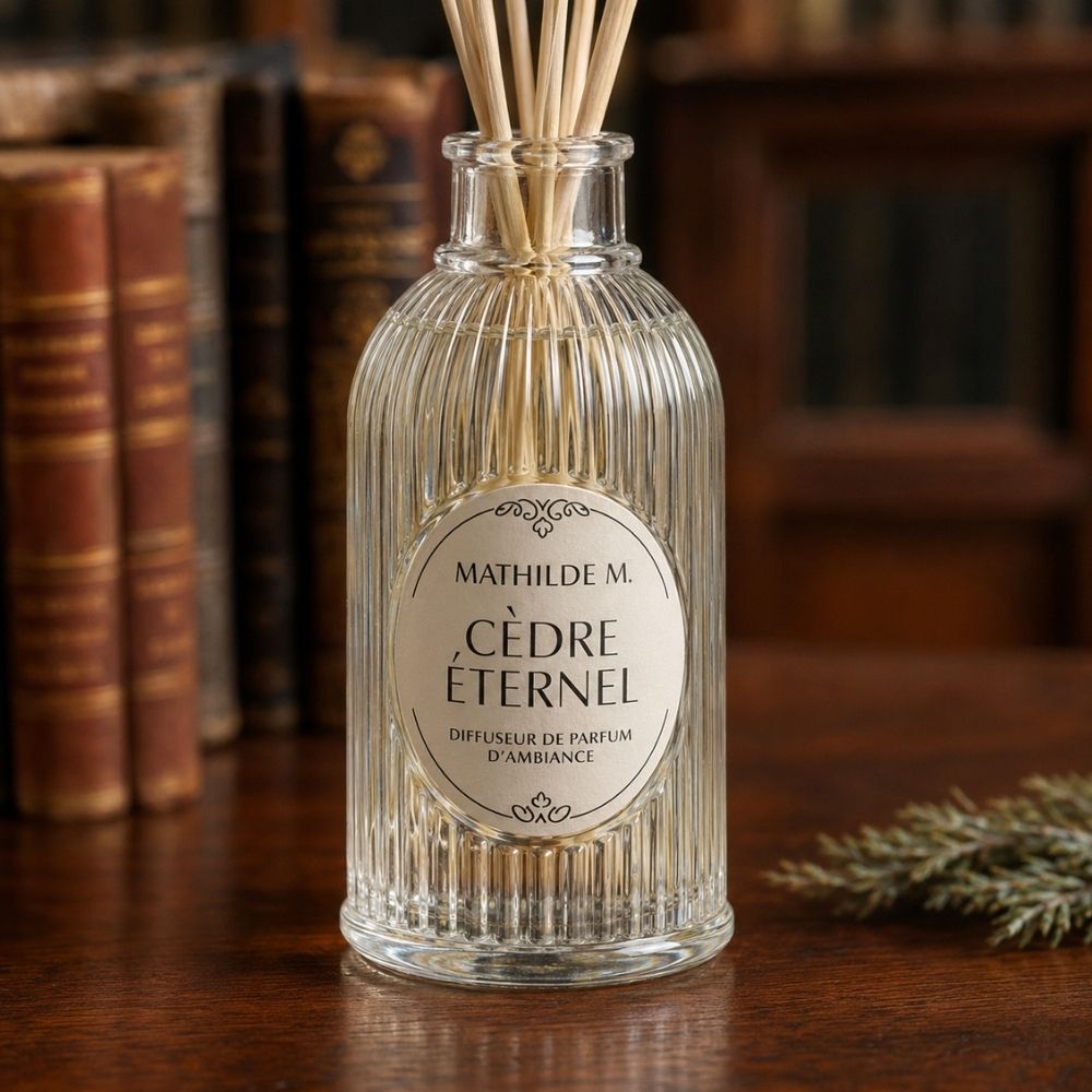Detalle de la etiqueta del ambientador mikado Cèdre Éternel de Mathilde M junto a libros antiguos de piel – D'Arome