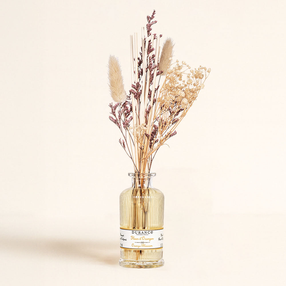 Frasco de vidrio del ambientador mikado Flor de Azahar de Durance con su ramo de flores secas naturales y varillas de ratán.