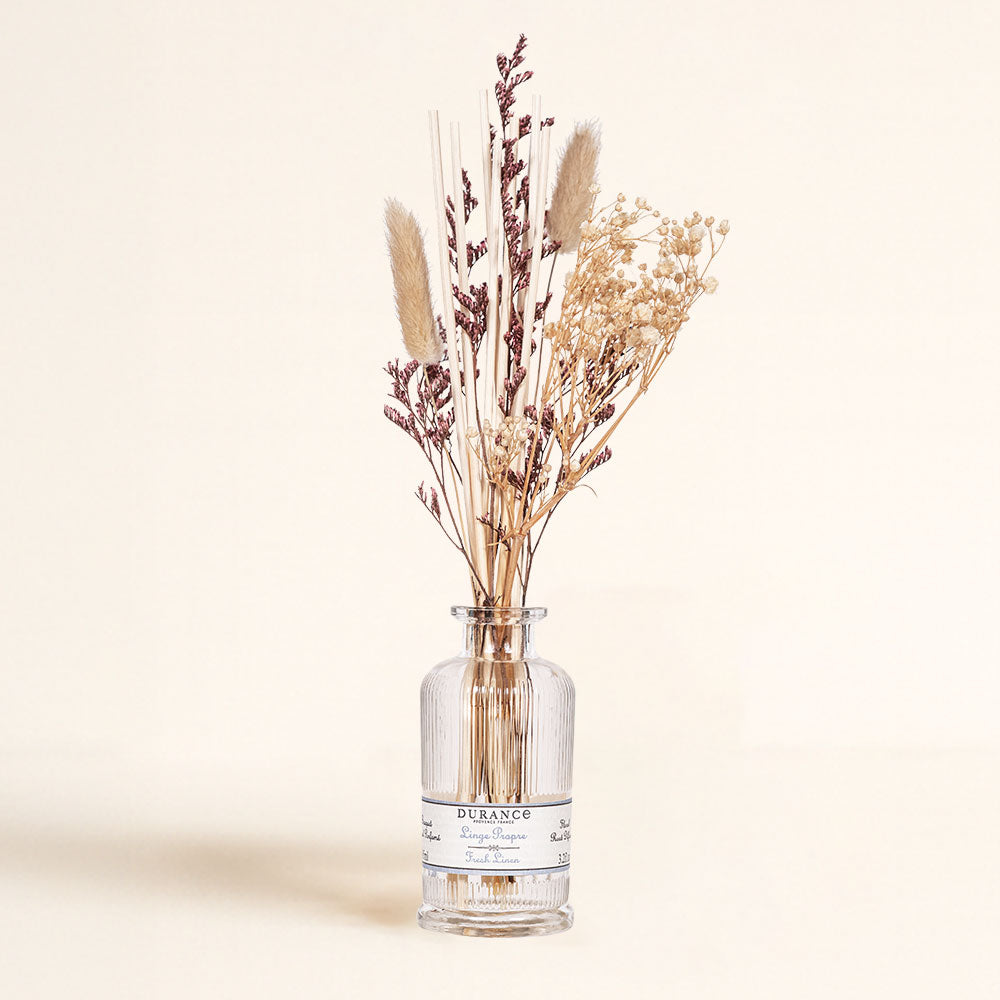 Frasco de vidrio del ambientador mikado Ropa Limpia de Durance en detalle, con su ramo de flores secas naturales y varillas de ratán.