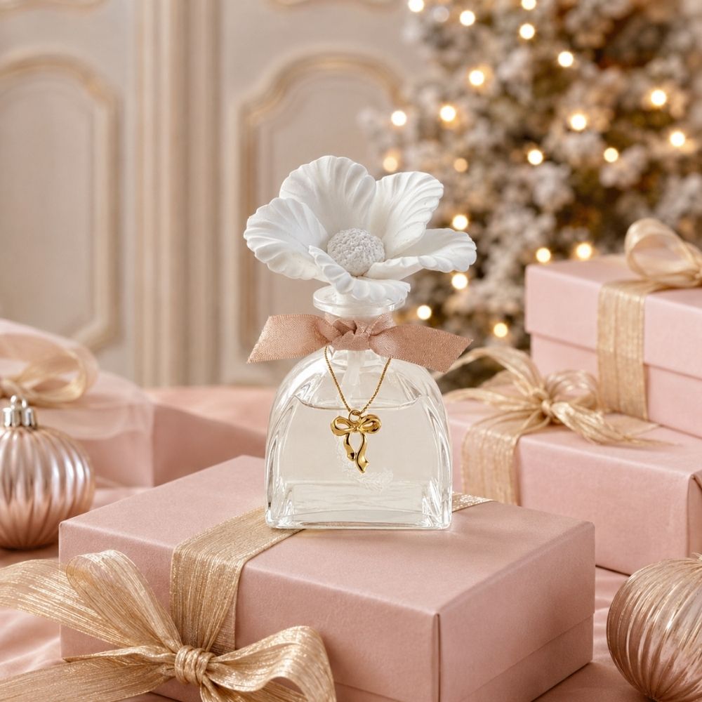Ambientador mikado con aroma Orange Cannelle de 100ml de Mathilde M con flor de porcelana blanca y lazo rosa, y clgante dorado. Crea el mejor ambiente navideño – D'Arome