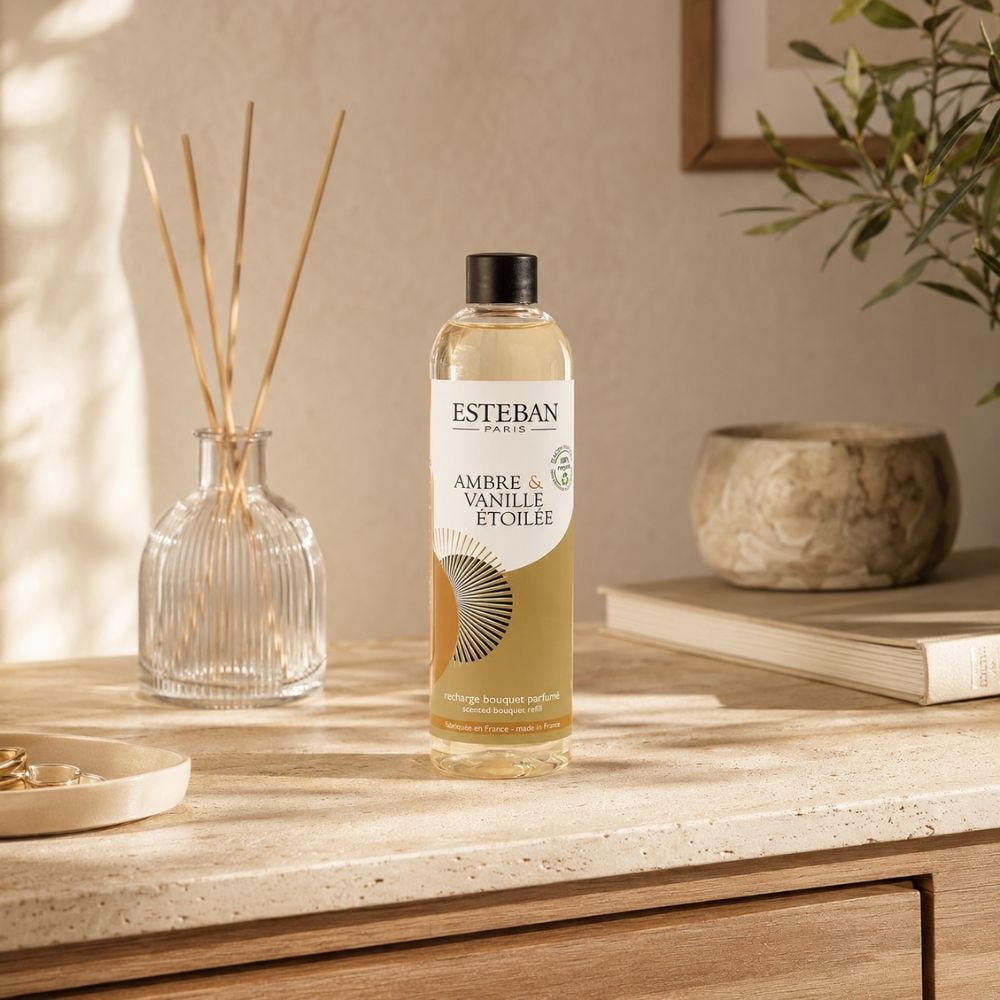 Recambio ambientador mikado Ambre et Vanille Étoilée Esteban París de 250 ml junto a envase de mikado y decoración en recibidor casa – D'Arome