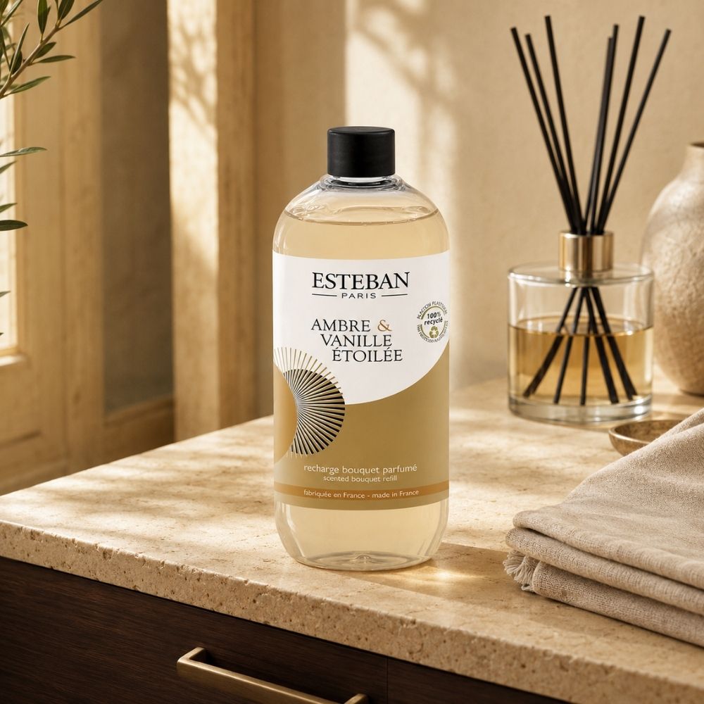 Recambio ambientador mikado Ambre et Vanille Étoilée Esteban París de 500 ml junto a envase sobre encimera de piedra clara en baño – D'Arome