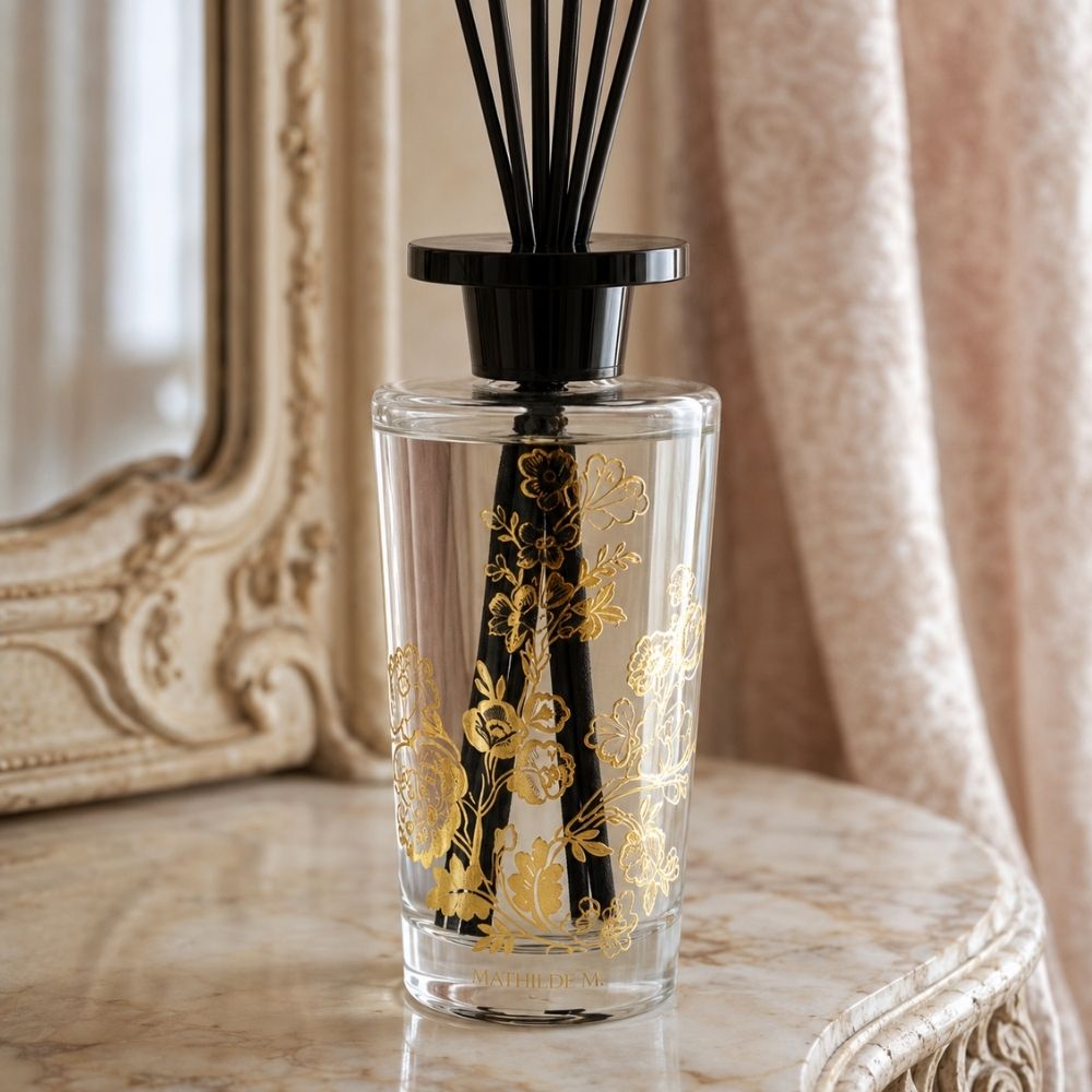 Detalle del frasco de cristal con estampado floral dorado del ambientador mikado Trésor de Fleurs con el aroma Marquise Mathilde M – D'Arome