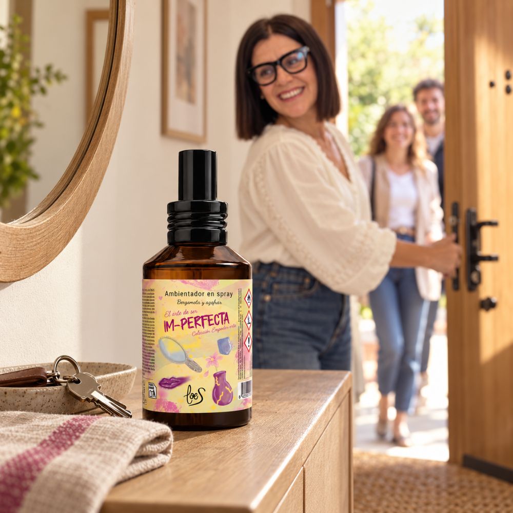 Ambientador spray Im-Perfecta de LoeS en la entrada de una casa que huele a hogar, perfuma al instante cuando llegan invitados sonriendo por la puerta – D'Arome