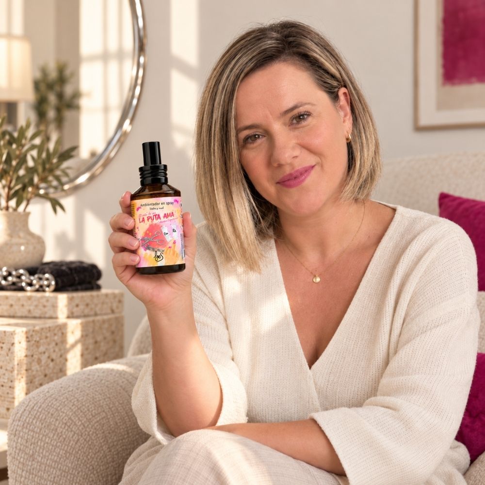 Ana Belén, fundadora de D’Arome, enseña el ambientador en spray La Puta Ama de LoeS sentada en el sofá del salón – D’Arome