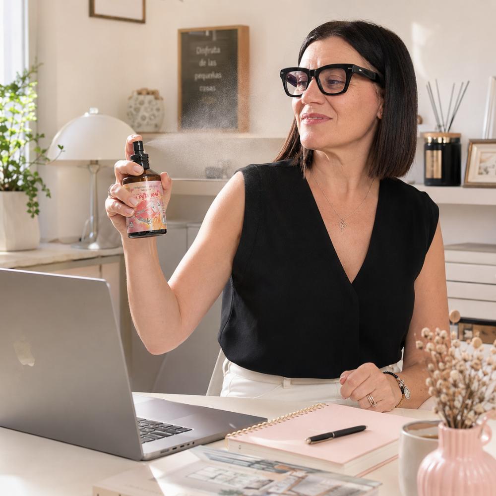 María Carmen, experta en aromas de D'Arome, aplicando spray La Puta Ama LoeS violeta y musk en su oficina frente al ordenador