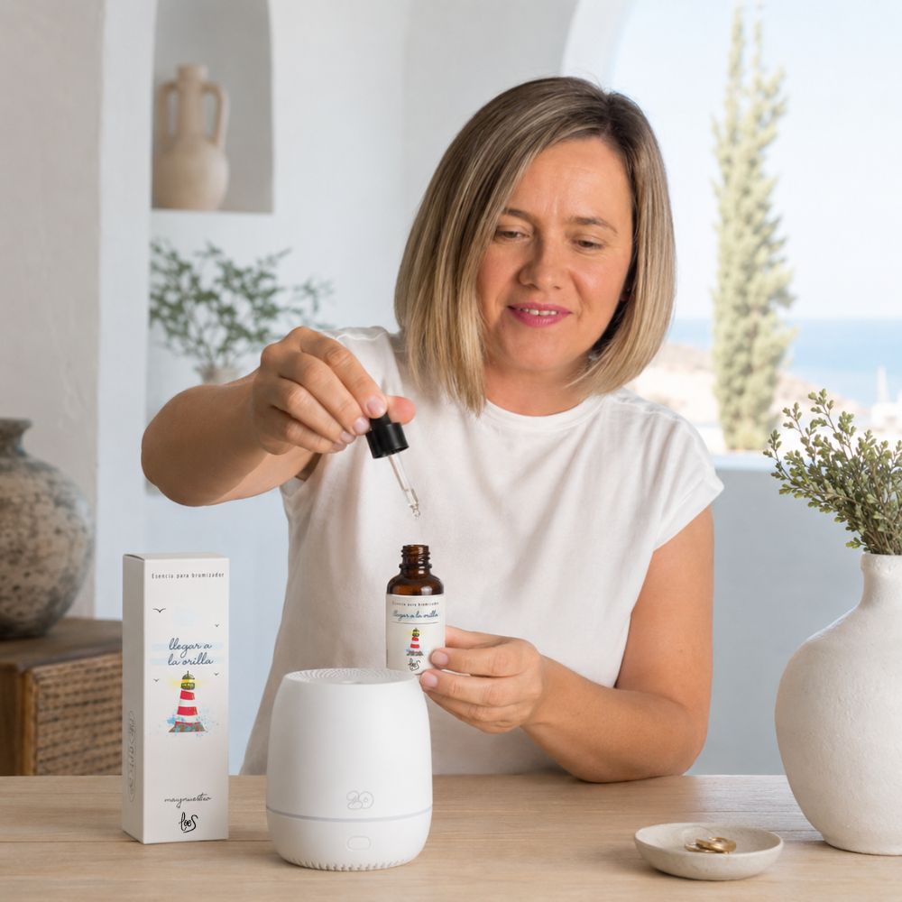 Ana Belén, del equipo de D'Arome, mostrando cómo usar la esencia para difusor de aromas "Llegar a la orilla" de LoeS, echando unas gotas con el cuentagotas en el difusor eléctrico – D'Arome