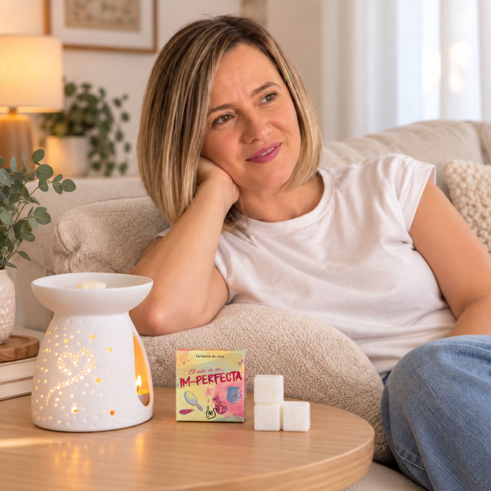 Ana Belén fundadora de D'Arome, relajada en el sofá junto a la tartaleta de cera Im-Perfecta de LoeS y su quemador encendido – D'Arome