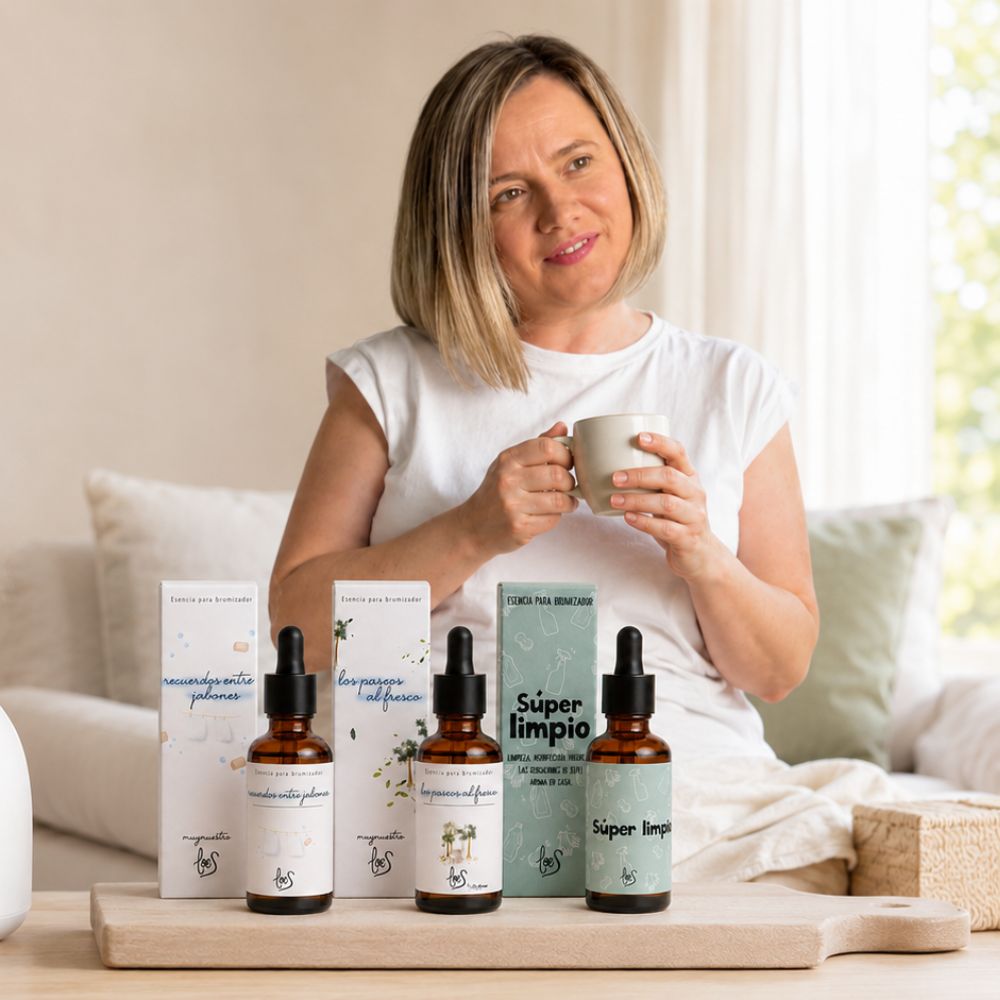 Ana Belén, cofundadora de LoeS by D'Arome, sosteniendo una taza junto al pack de aromas limpios Recuerdos entre Jabones, Paseos al Fresco y Súper Limpio – D'Arome