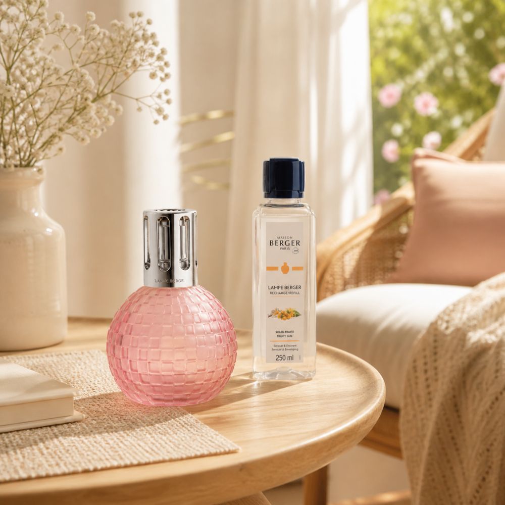 Cofre Disco Rosa Escarchada Maison Berger con Soleil Fruité en mesa de terraza veraniega