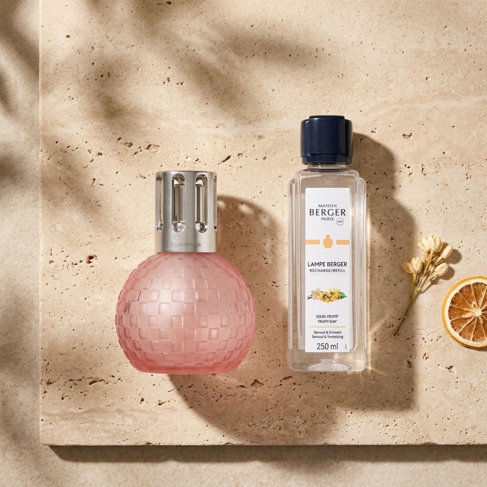Lámpara Disco Rosa Escarchada Maison Berger sobre piedra natural con rodaja de naranja y flores secas