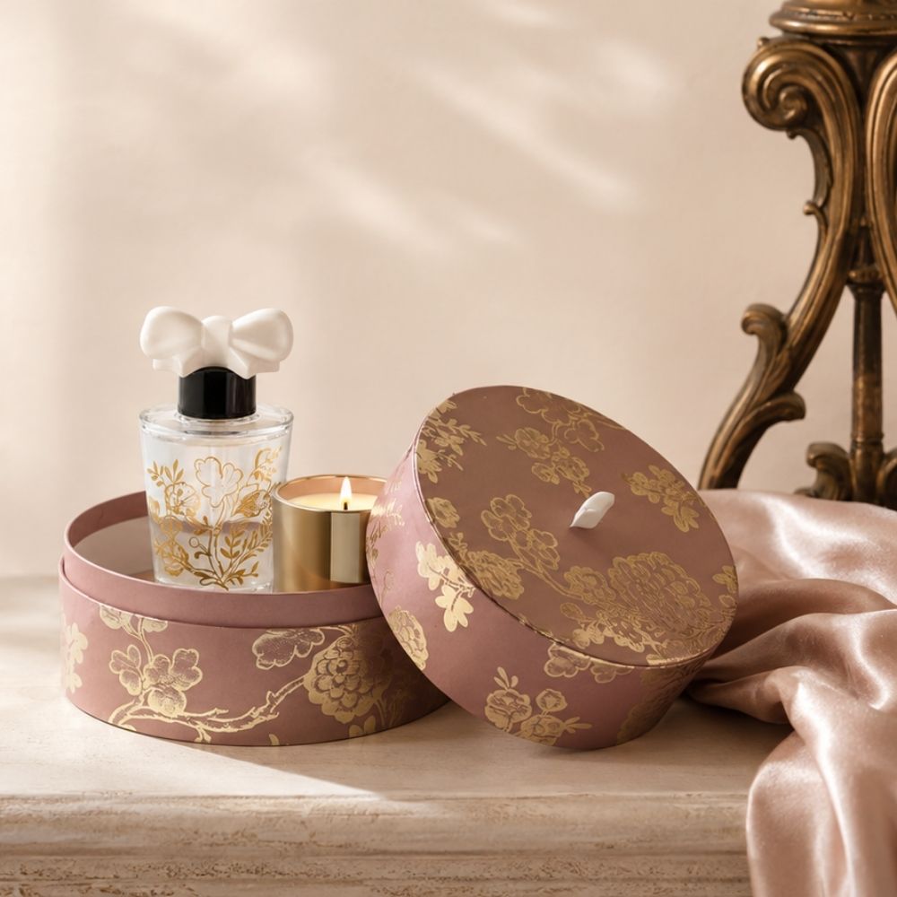 Cofre regalo colección Trésor de Fleurs del icónico aroma Marquise de Mathilde M con la vela perfumada encendida junto al ambientador mikado con forma de lazo cerámico – D'Arome