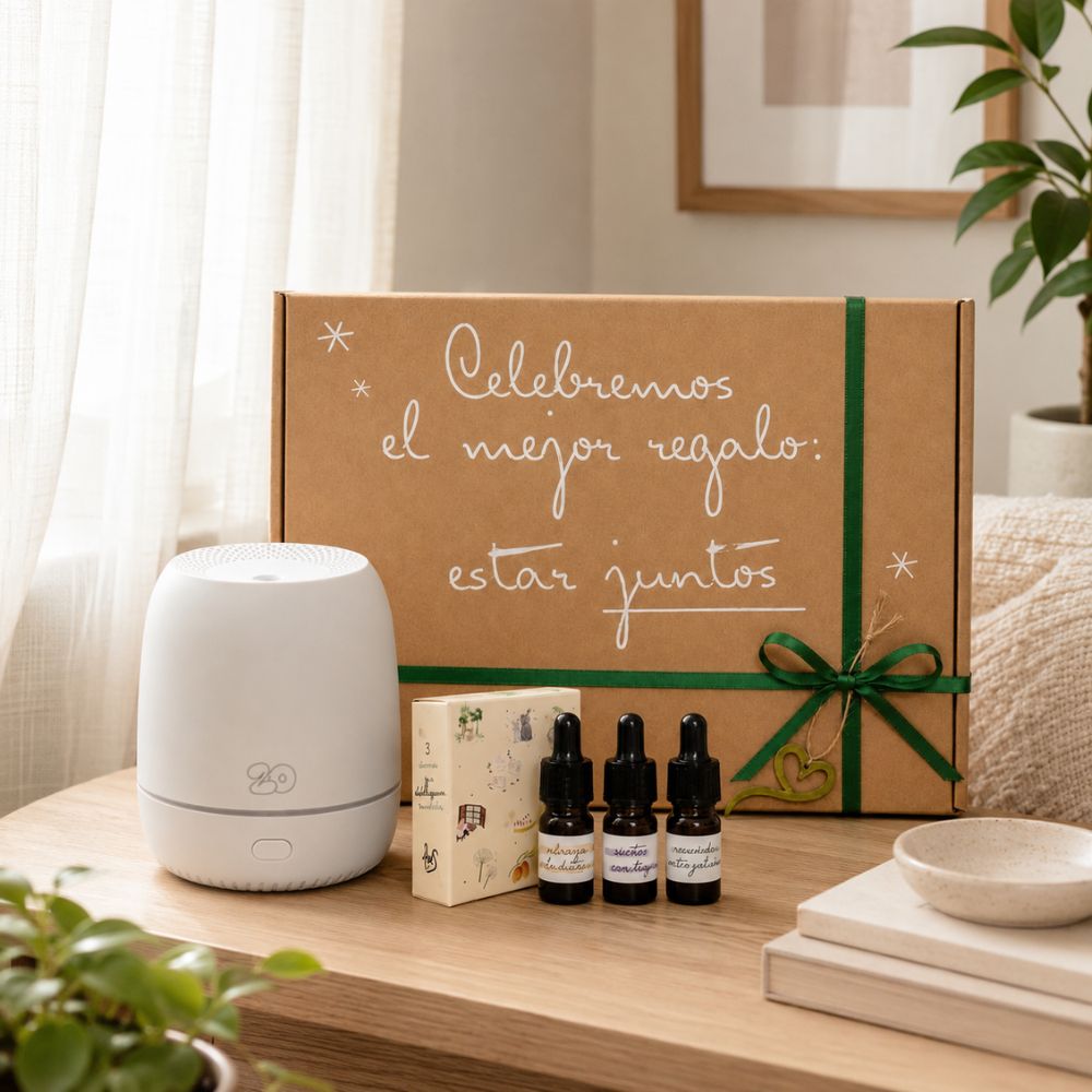 Difusor Sira emitiendo vapor aromático con trío de mini esencias LoeS y caja regalo kraft con lazo verde y corazón sobre mesita de dormitorio – D'Arome