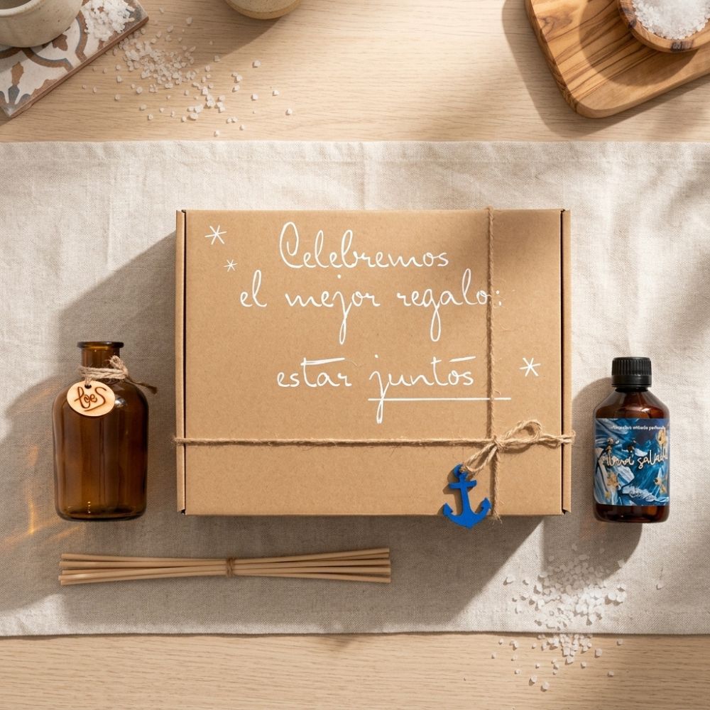 Flatlay del cofre regalo de verano mikado Alma Salada de LoeS con frasco de cristal ámbar, varillas y recambio perfumado sobre mesa de madera con sal marina, conexión con los ingredientes del aroma – D'Arome