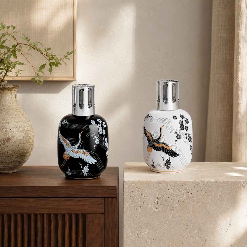 Colección Sakura de Maison Berger en acabado blanco y negro, lámparas reunidas junto a jarrón cerámico y ramas florales – D'Arome