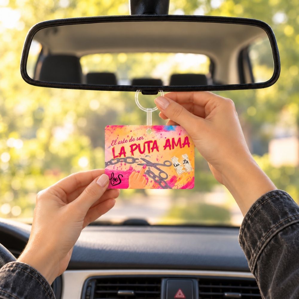 Manos colgando del espejo retrovisor la tarjeta perfumada La Puta Ama de LoeS, así de fácil se pone el ambientador de coche – D’Arome