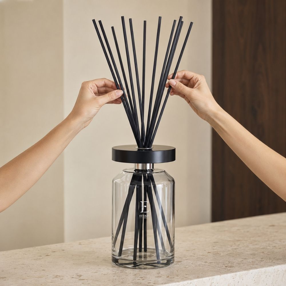 Manos colocando las varillas de bambú del difusor Ellipse Figue Noire de Esteban Paris para activar la difusión del aroma – D'Arome