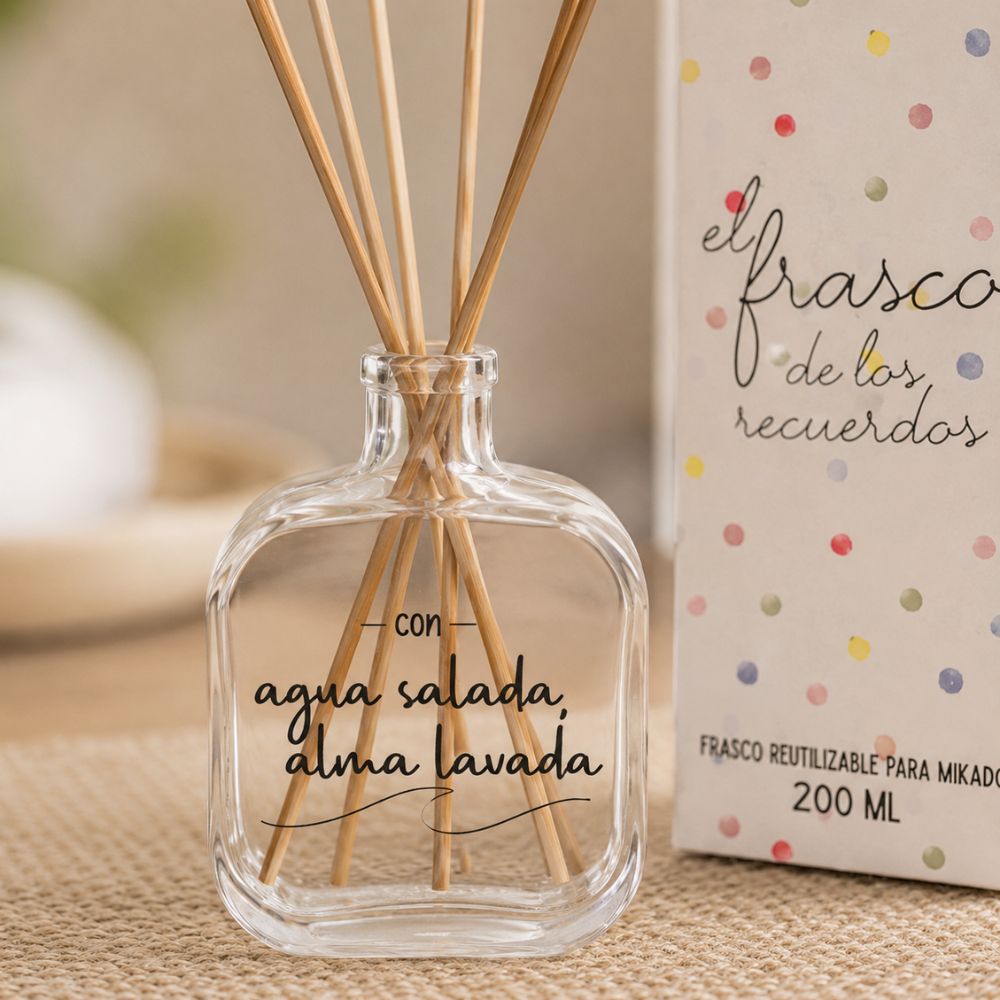 Detalle del frasco mikado reutilizable 200ml de cristal con lettering Agua Salada Alma Lavada de LoeS, varillas de ratán y caja sobre mantel de yute natural – D'Arome
