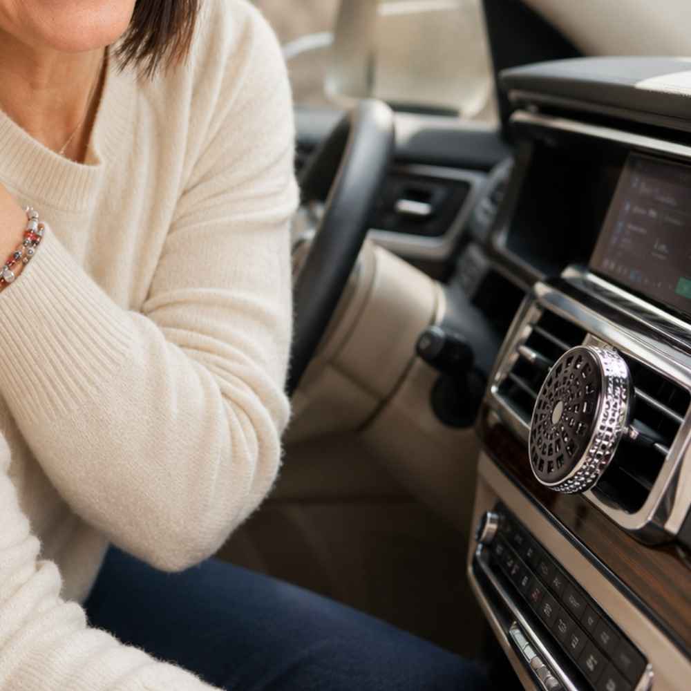 Difusor de coche negro Maison Berger instalado en la rejilla de ventilación de un vehículo – D'Arome