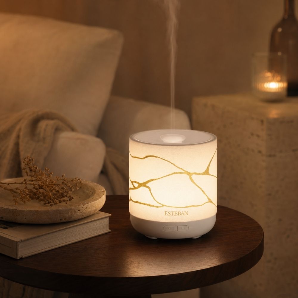 Difusor de bruma de perfume Easy Living White & Gold Esteban París encendido con efecto luz de vela junto a decoración – D'Arome