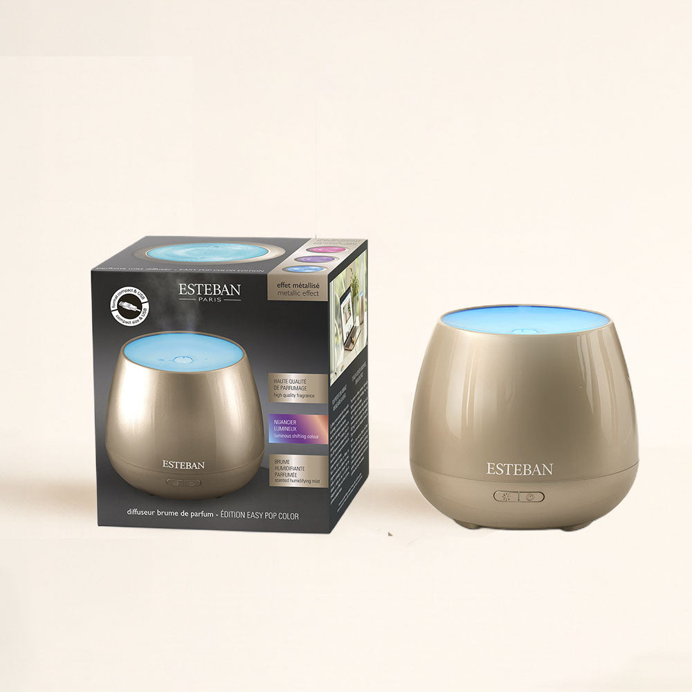 Difusor de aromas Easy Pop Platinium Esteban Paris encendido junto a su caja, acabado metalizado – D'Arome