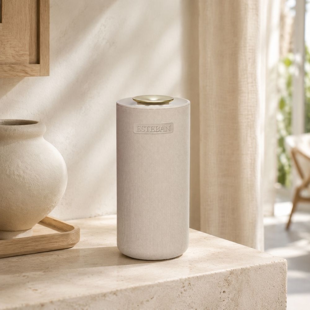 Difusor de aromas (sin agua) y altavoz incorporado Easy Sound Esteban París con revestimiento textil beige sobre repisa de piedra en salón cálido - D'Arome