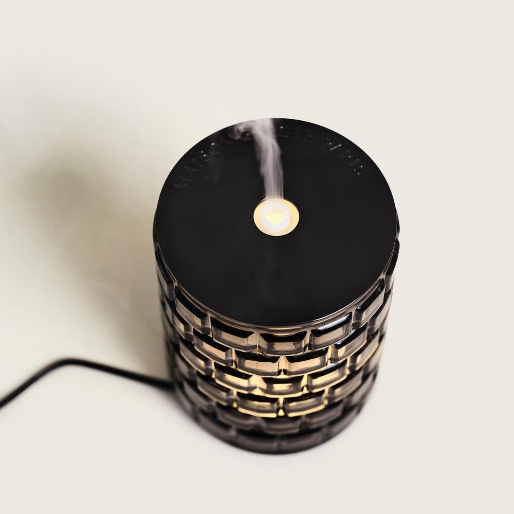 Vista cenital del difusor eléctrico Celebration Maison Berger encendido con vapor aromático saliendo por la boquilla superior y luz cálida interior – D'Arome