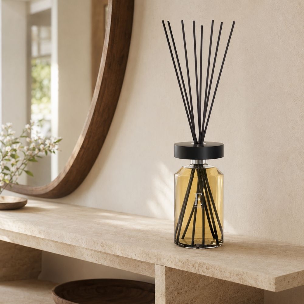 Difusor Ellipse Néroli de Esteban Paris sobre una repisa de piedra travertino, reflejado junto a un espejo circular de madera – D'Arome