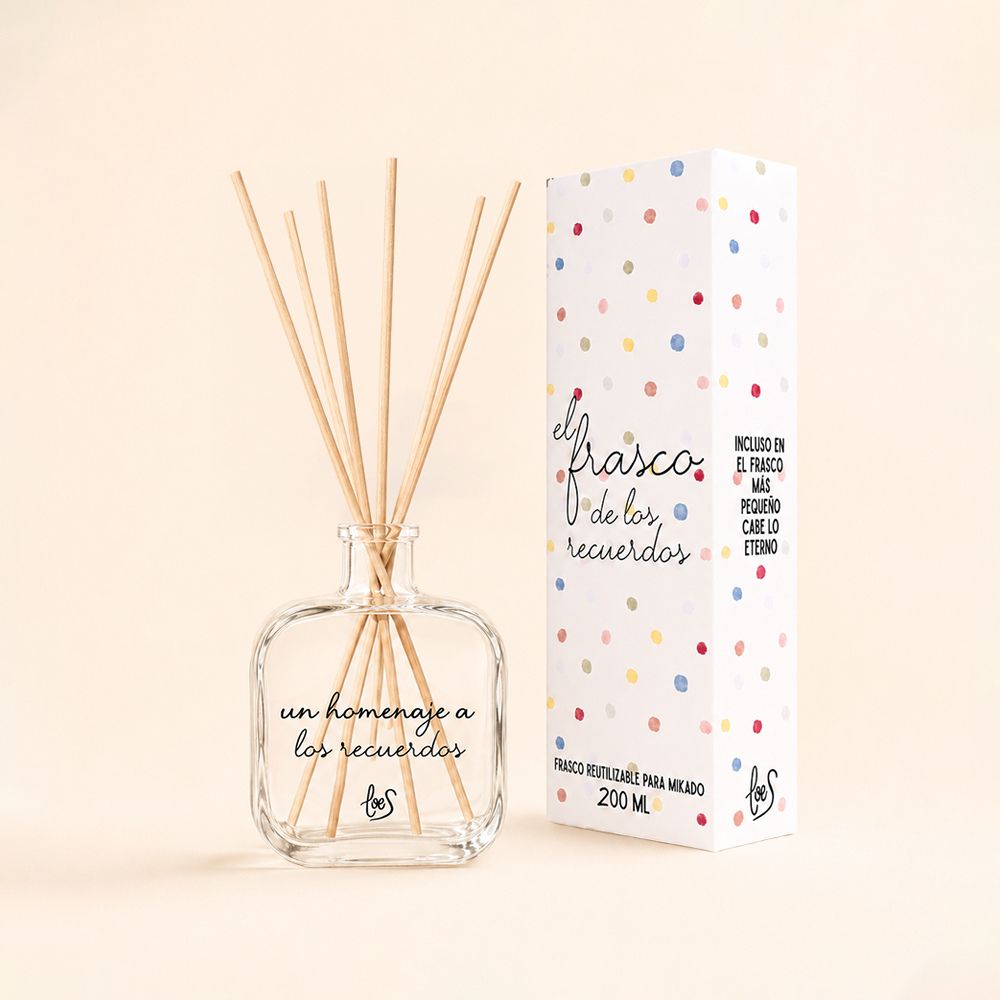Envase mikado vacío 200ml de cristal con lettering "Un homenaje a los recuerdos" de LoeS y caja "El Frasco de los Recuerdos" sobre fondo neutro crema – D'Arome