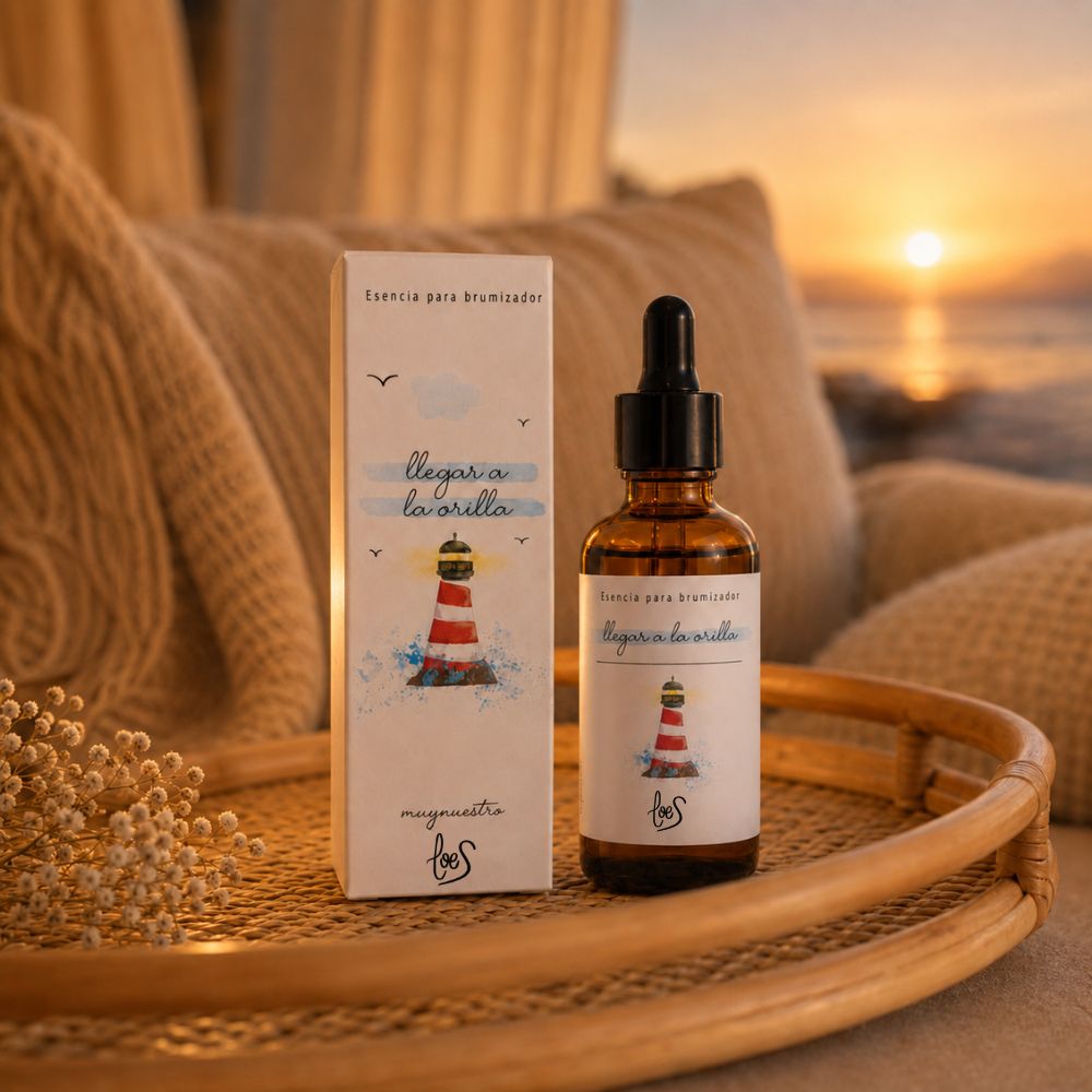 Esencia para difusor de aromas "Llegar a la orilla" de LoeS sobre madera deriva en una playa de piedras al atardecer, evocando la calma después de la tormenta – D'Arome