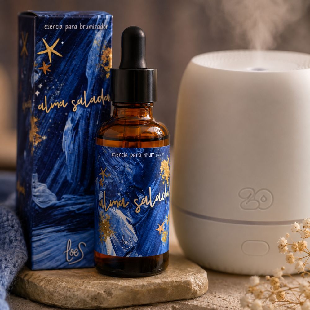 Esencia para brumizador Alma Salada de LoeS junto al difusor Sira emitiendo vapor aromático en ambiente cálido con flores secas, sobre base de piedra natural – D'Arome