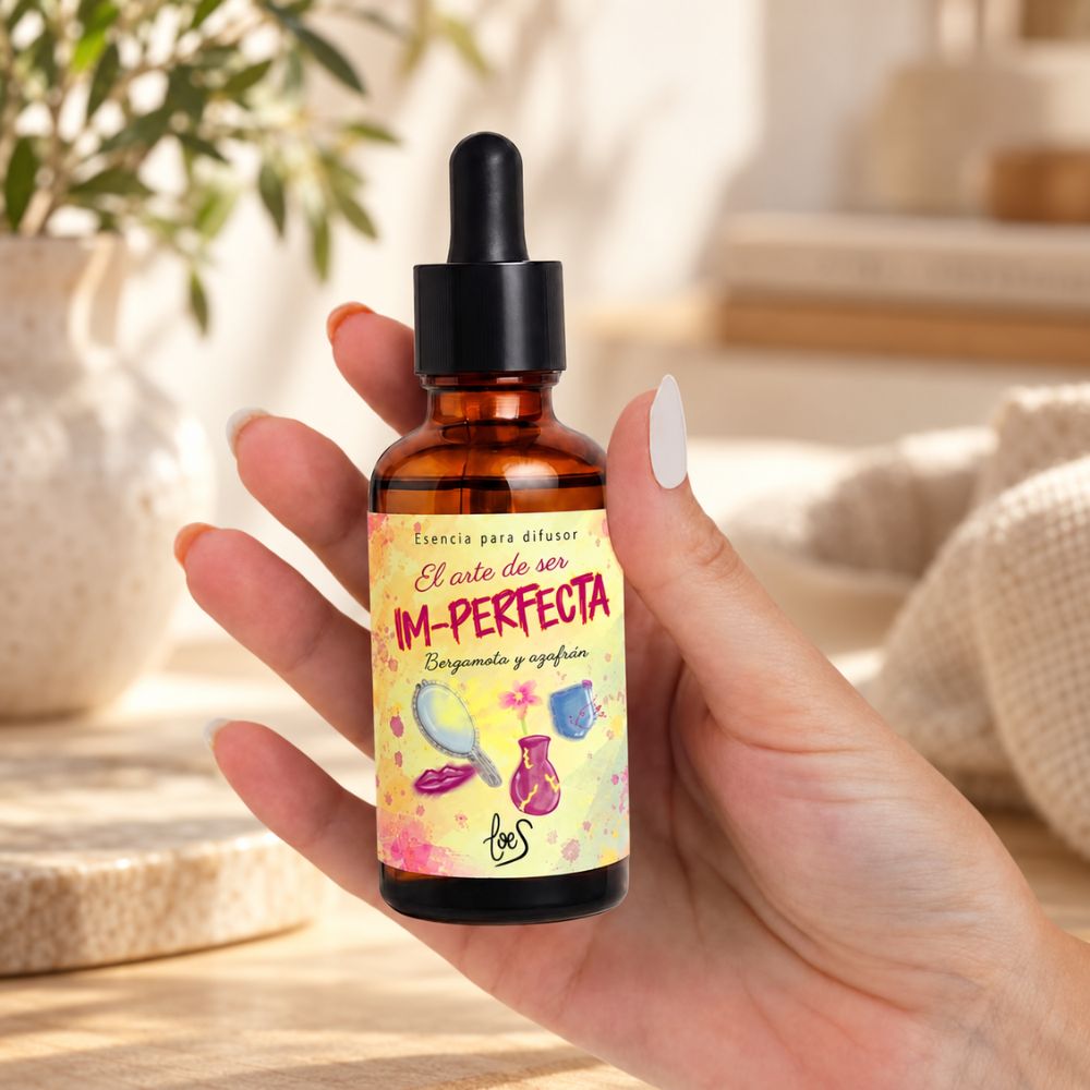 Mano sosteniendo el frasco de esencia para difusor Im-Perfecta de LoeS, bergamota y azafrán de LoeS – D'Arome