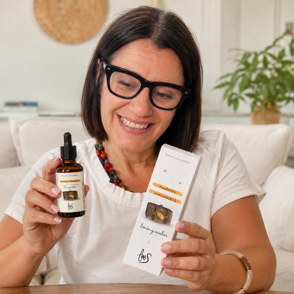 Mari Carmen, fundadora y CEO de D'Arome, sosteniendo el frasco y la caja de esencia Nuevos Comienzos LoeS limón y azahar, especialista en aromas para el hoga