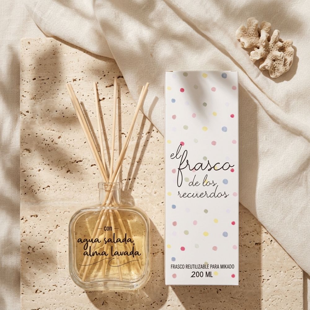 Flatlay del frasco mikado 200ml Agua Salada Alma Lavada de LoeS con caja "El Frasco de los Recuerdos" sobre travertino, lino y coral marino – D'Arome