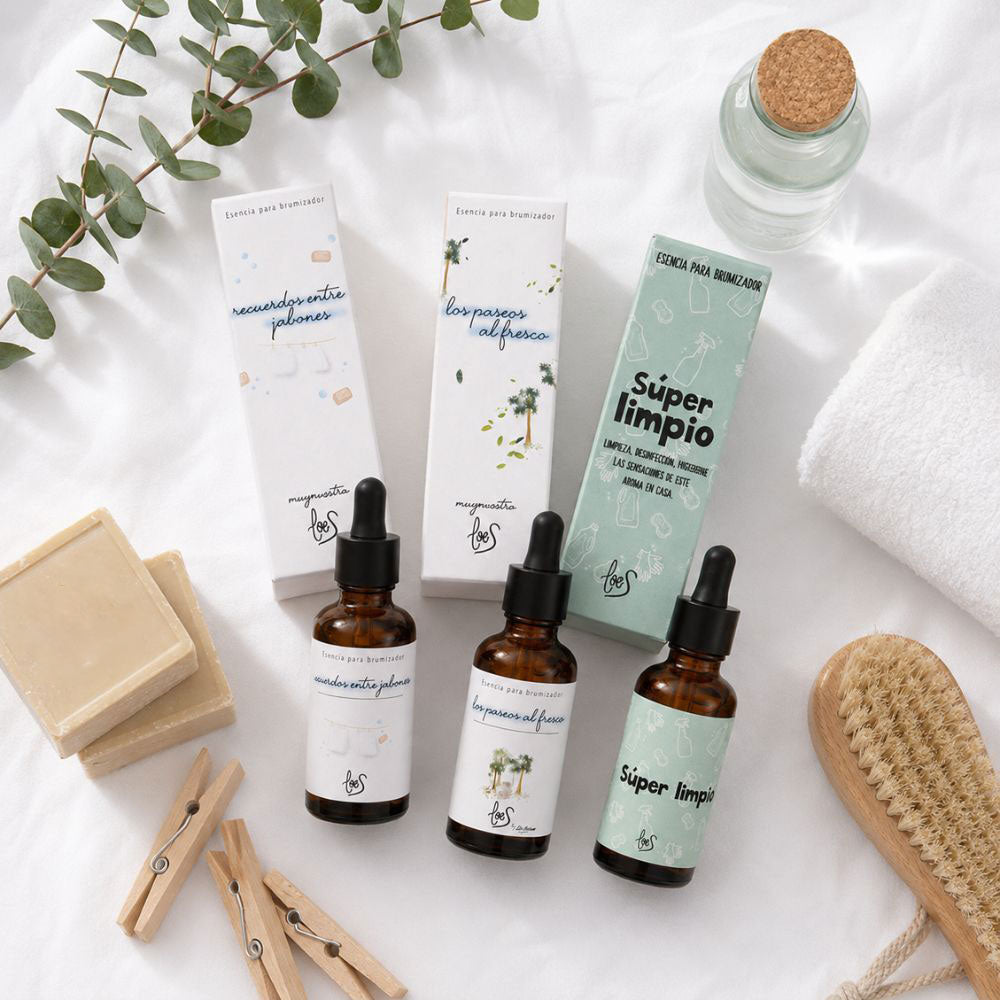 Flatlay del pack tres esencias limpias LoeS con jabón de Marsella, eucalipto, pinzas de madera y cepillo natural sobre tejido blanco – D'Arome