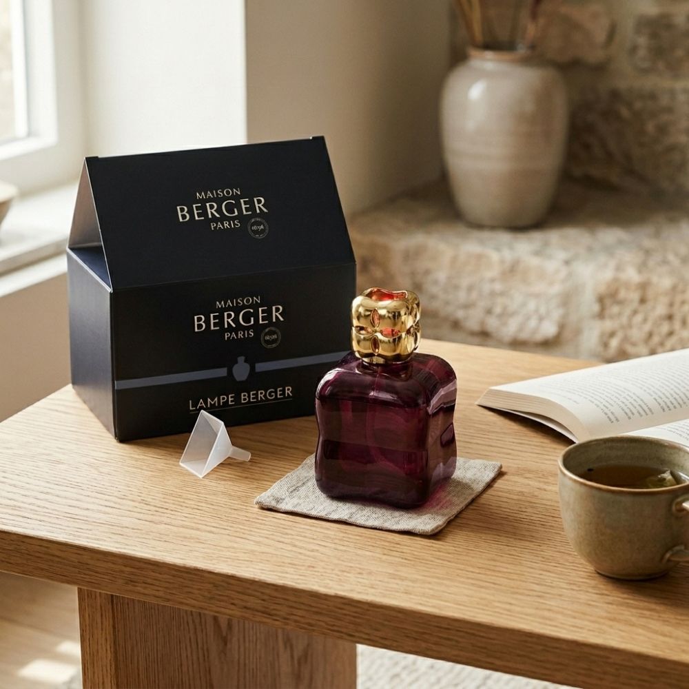 Lámpara catalítica Cosy Granate junto a su caja regalo Maison Berger Paris en mesa de madera