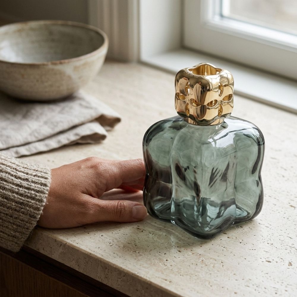 Mujer colocando la Lámpara catalítica Cosy Verde Maison Berger en encimera de cocina
