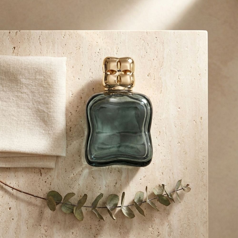 Lámpara catalítica Cosy Verde Maison Berger sobre piedra natural con rama de eucalipto