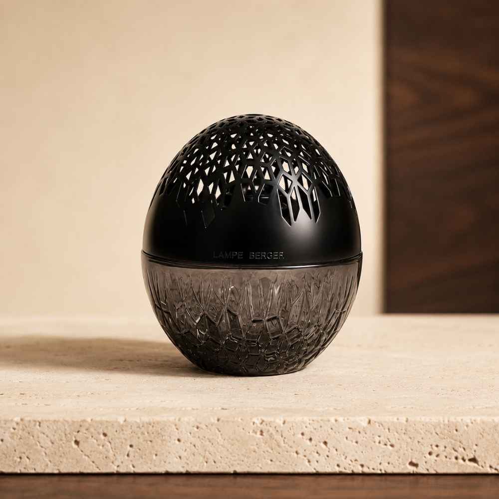 Detalle de la lámpara catalítica Luka Negra Maison Berger con su capuchón calado 100% negro sobre mueble de madera oscura – D'Arome