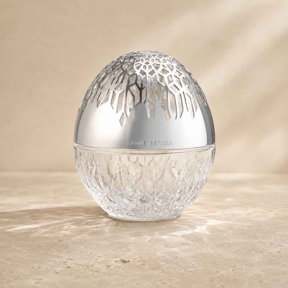Detalle de la lámpara catalítica Luka Transparente Maison Berger con capuchón plateado calado sobre superficie de mármol claro – D'Arome