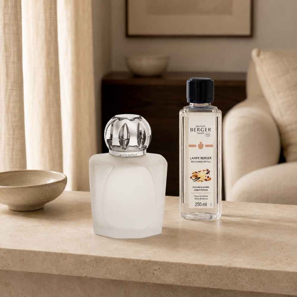 Lámpara catalítica Magical Esmerilada Maison Berger con montura plateada junto al recambio Amber Powder 250ml  en un salón cálido – D'Arome
