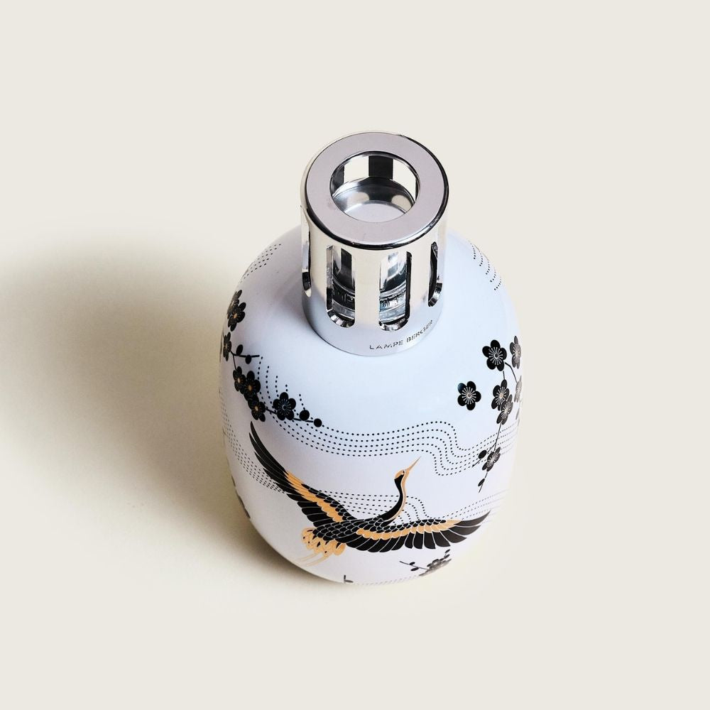 Vista cenital de la lámpara catalítica Sakura Blanca Maison Berger con ilustración japonesa de flores de cerezo y grulla en tonos negros y dorados – D'Arome