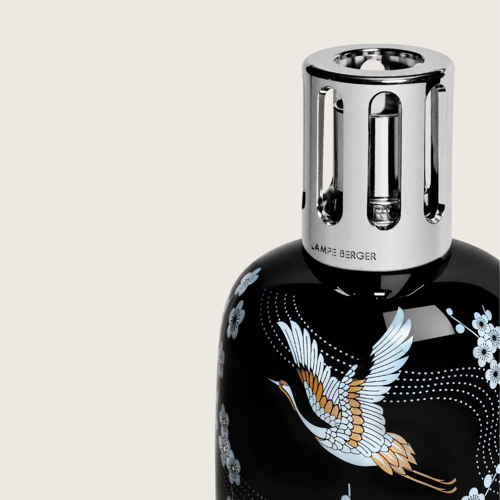 Detalle de la montura plateada de la lámpara catalítica Sakura Negra Maison Berger con grabado Lampe Berger sobre cerámica negra con ilustración japonesa de grulla y flor de cerezo – D'Arome