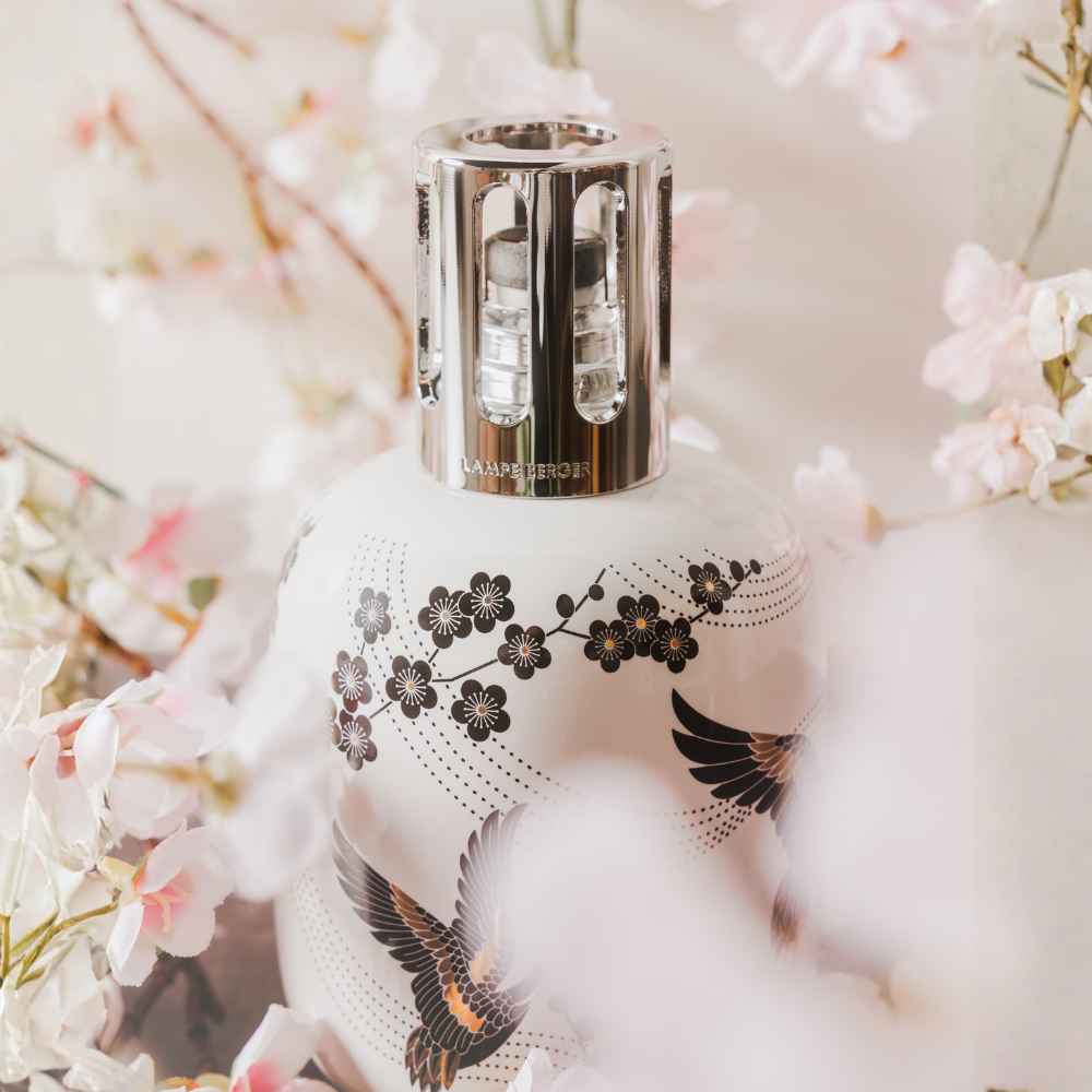 Detalle del capuchón plateado de la lámpara catalítica Sakura Blanca Maison Berger entre flores de cerezo – D'Arome