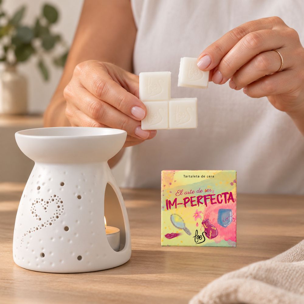 Manos mujer separando un trocito de la tartaleta de cera Im-Perfecta de LoeS para colocarlo en el quemador de aromaterapia corazón – D'Arome